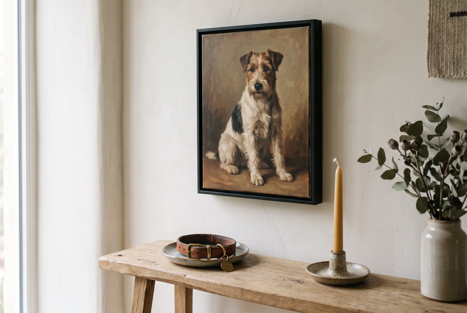 Gemaltes Hundeportrait im schlanken schwarzen Floater-Rahmen über einer schmalen Eichenkonsole, darauf das Lederhalsband in einer Keramikschale, eine Kerze und getrockneter Eukalyptus.